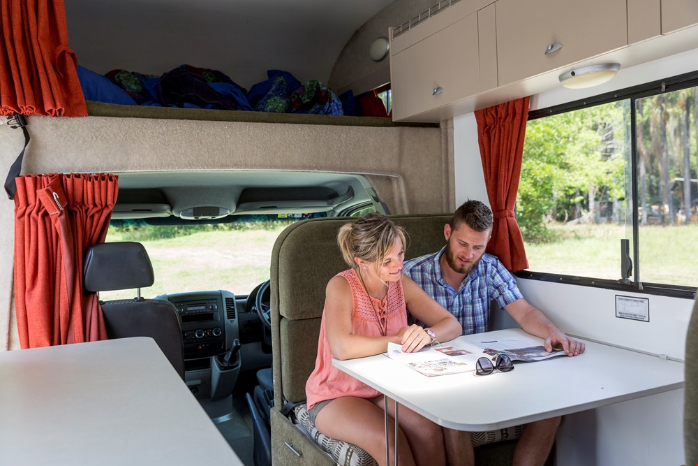Man and Woman Reading a Magazine - Campervan Hire Sydney - Campervan Rental Shop